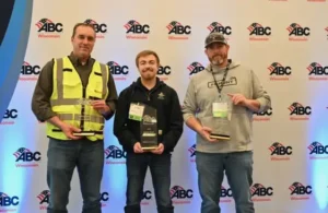 Three men holding awards